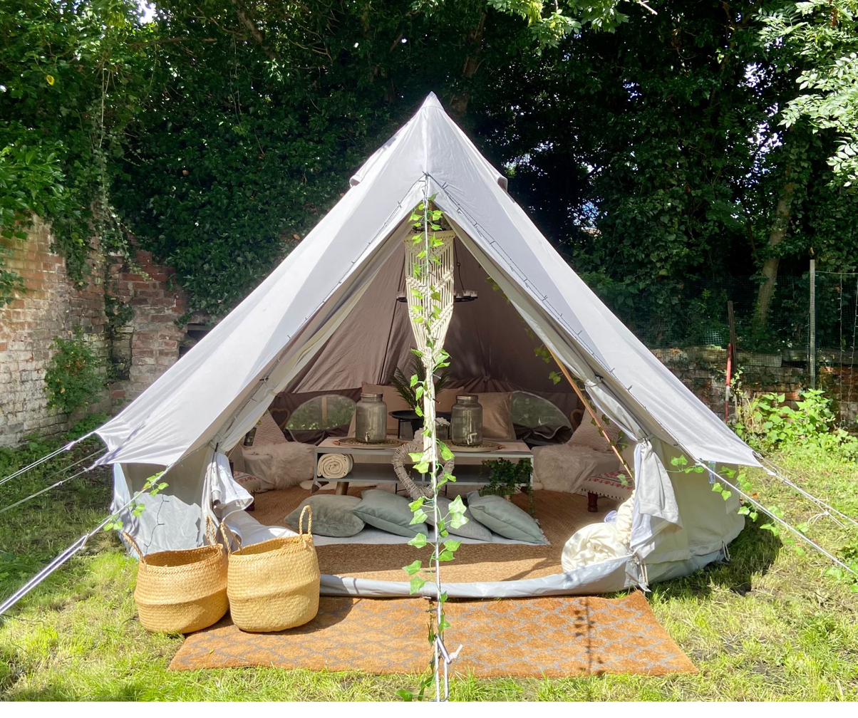 White bell tent pitched outdoors in a garden in Northwich, decorated for a children's birthday party