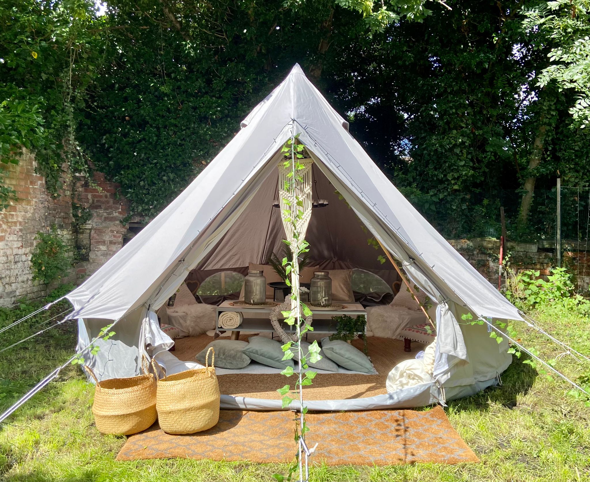 Boho-styled bell tent hire Cheshire setup in a garden with macramé hangings and natural decor