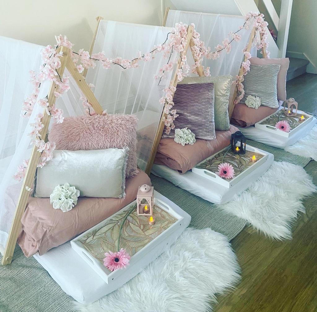 Blush teepees decorated with a blossom garland for a dreamy children's sleepover party