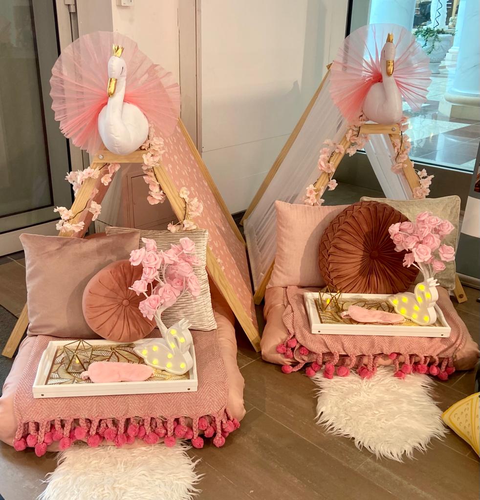 Swan themed pink teepees set up for a children's sleepover party