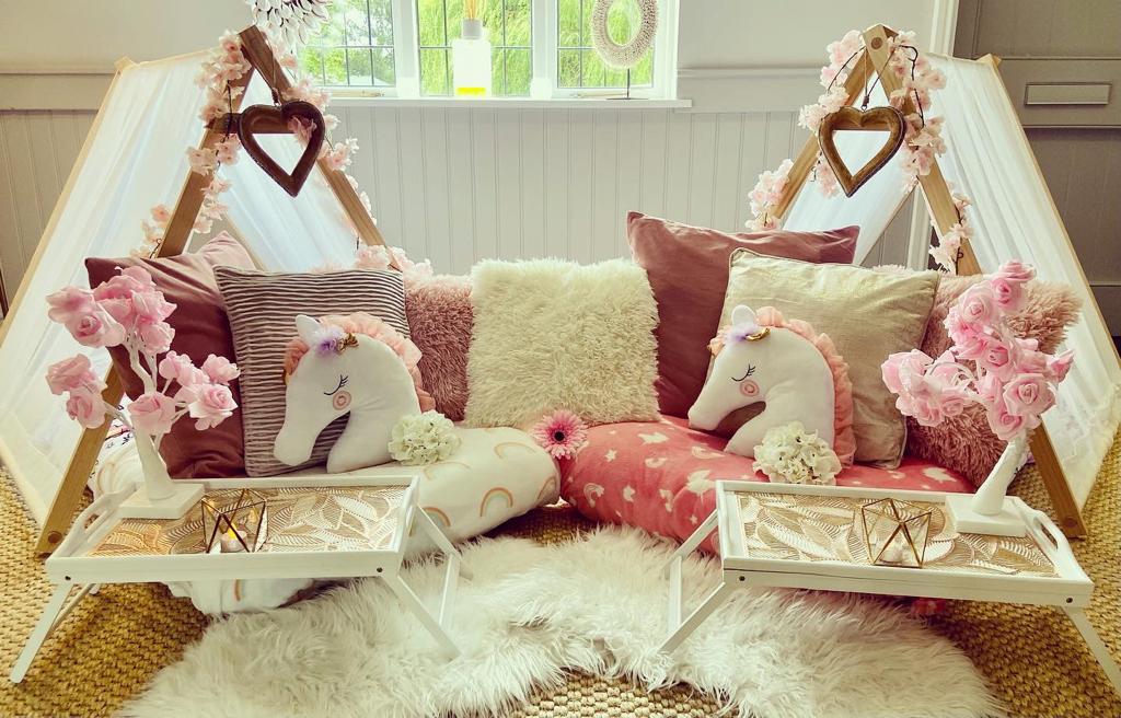 Unicorn themed blush pink teepees set up for a children's sleepover party